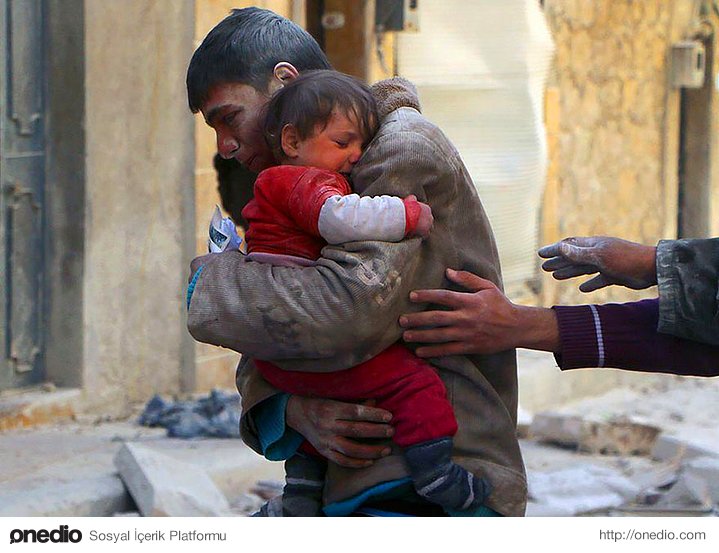 Suriyeli bir genç, kız kardeşini evlerinin enkazı altından kurtardıktan sonra.