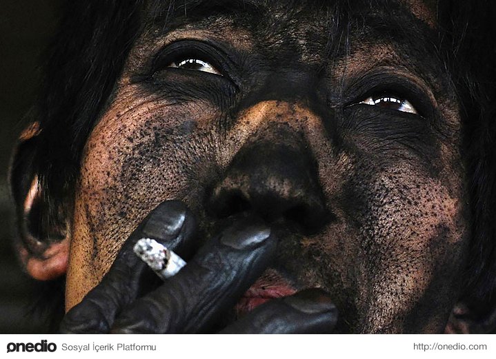 Changzhi'de bir kömür madeninde, vardiyasını bitiren bir maden işçisi sigarasını içiyor.